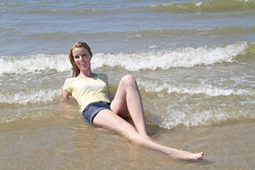 beautiful happy woman lying in the water from the ocean