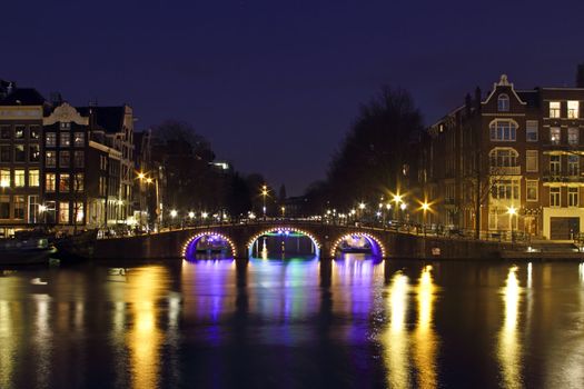 City scenic from Amsterdam by night at the river Amstel in the Nethrlands