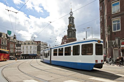 Driving tram in front of the Munt tower in Amsterdam the Netherlands