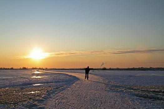 Ice skating in the countryside from the Netherlands at sunset