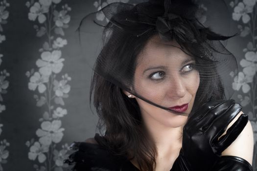 Portrait of young sexy woman in black veil on vintage wall