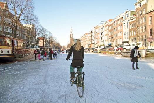 Biking on frozen canals in Amsterdam the Netherlands