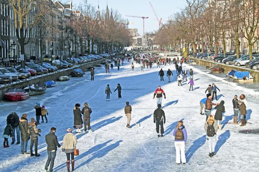 Ice skating on the canals in Amsterdam the Netherlands in winter