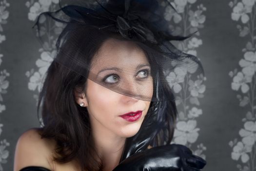 Portrait of young sexy woman in black veil on vintage background