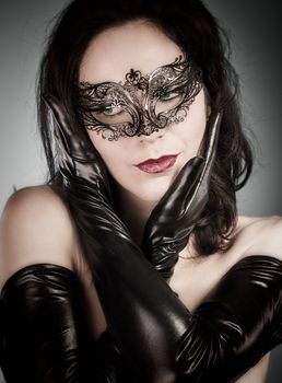 Venetian Mask. A pretty retro girl in black wearing a cute hat and a scarf.