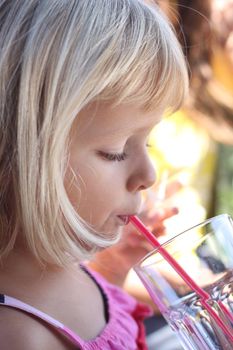Profile portrait of young child drinking with a straw