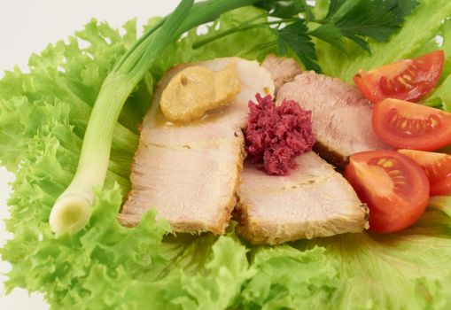 Sliced ​​baked ham with condiments on salad leaves