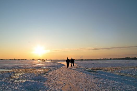 Ice skating in the countryside from the Netherlands at sunset