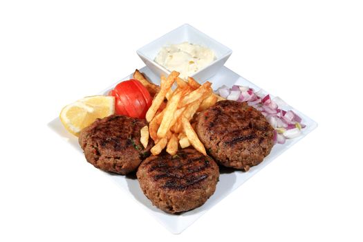 meat balls served with fried potatoes and vegetables on a plate isolated on a white background