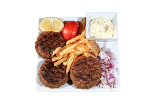 meat balls served with fried potatoes and vegetables on a plate isolated on a white background