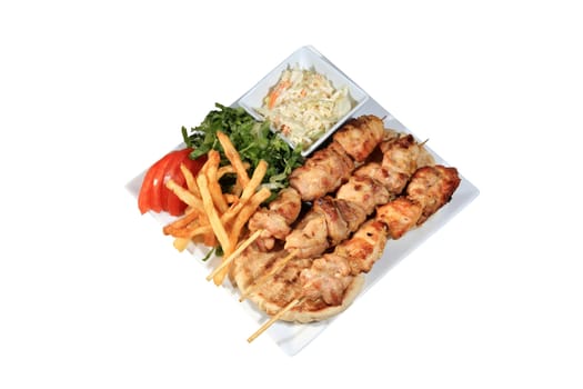 chicken skewers served on a plate with fried potatoes tzatziki and pita isolated on a white background