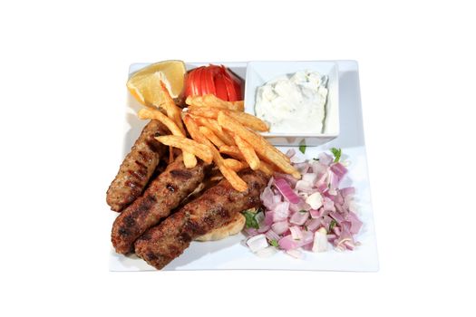 shish kebab served with fried potatoes and sauce on a plate with pita