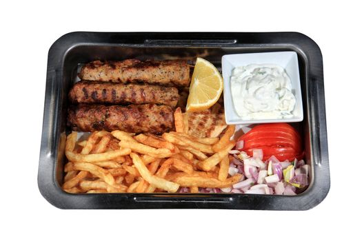 shish kebab served with fried potatoes and sauce on a metallic plate with pita