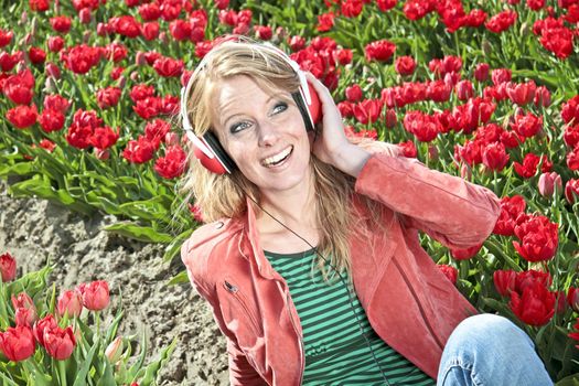 Happy girl enjoying the music in the tulip fields from the Netherlands