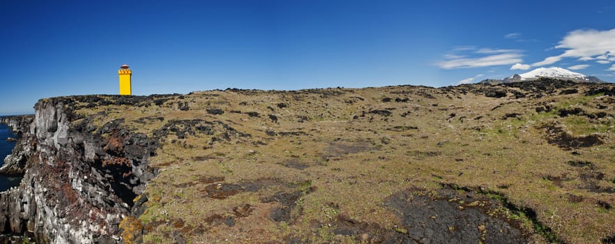 Small lighthouse on the cliff at Snaefellsnes, the western of Iceland. Panoramic photo with Snaefellsjokull volcano.