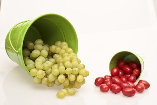 Tomatoes and grapes in a green bucket