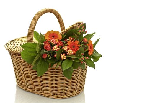 a bouquet of flowers in a wicker basket on a white background
