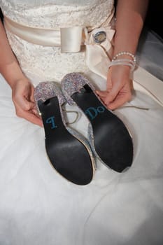 bride holding a pair of hand made shoes for the wedding day