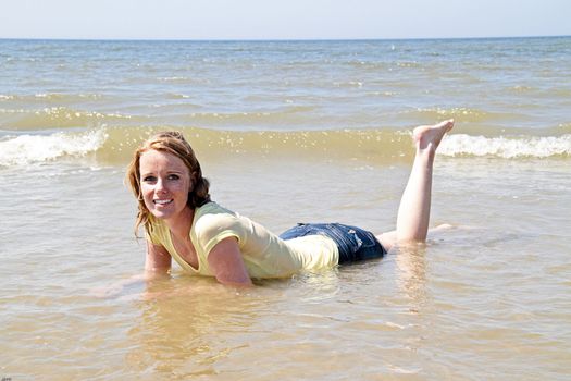 Happy woman lying in the water from the north sea