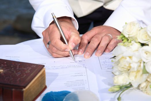 close up of hands signing at a wedding