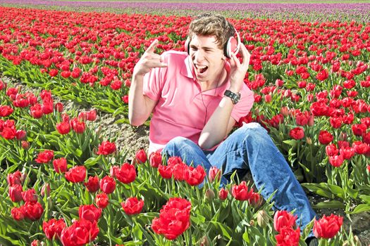 Happy guy listening to the music in the tulip fields from the Netherlands