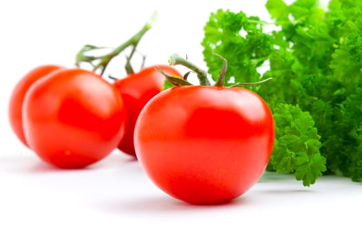 Red tomato with parsley isolated on white background.