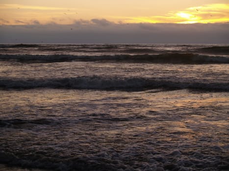 Beautiful Sunset Over the Ocean wth Waves in the Foreground