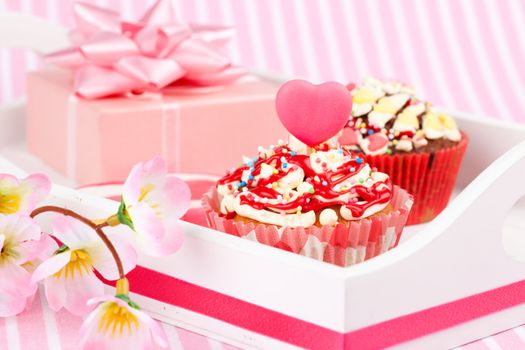 Valentine cupcake with a heart candle, isolated on a white background
