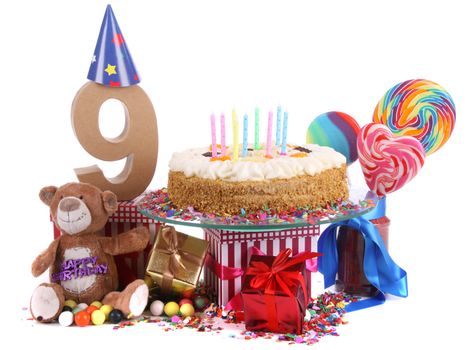 Number of age in a colorful studio setting with paper party hats, a red heart and gifts on a bottom of confetti and sweet cake with candles 
