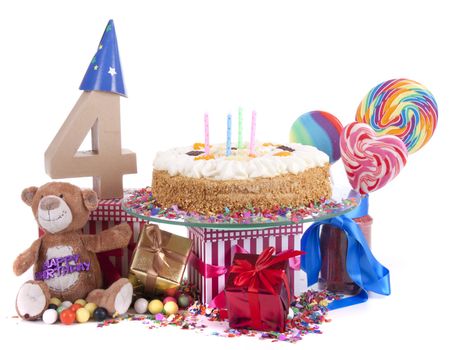 Number of age in a colorful studio setting with paper party hats, a red heart and gifts on a bottom of confetti and sweet cake with candles 