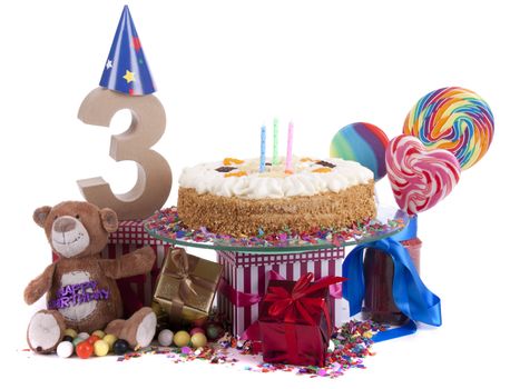 Number of age in a colorful studio setting with paper party hats, a red heart and gifts on a bottom of confetti and sweet cake with candles 