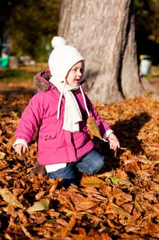 cute littloe girl playing outdoor in colorfull autumn park