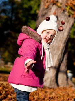 cute littloe girl playing outdoor in colorfull autumn park