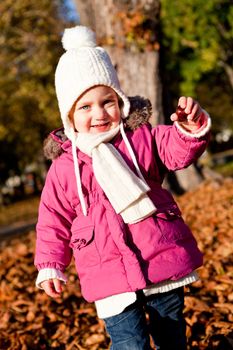 cute littloe girl playing outdoor in colorfull autumn park