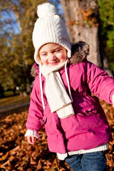 cute littloe girl playing outdoor in colorfull autumn park