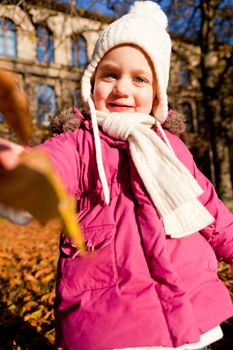 cute littloe girl playing outdoor in colorfull autumn park