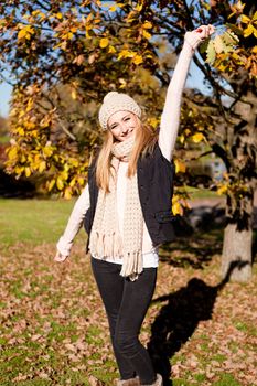 young woman in autumn sunshine outdoor in warm clothes lifestyle