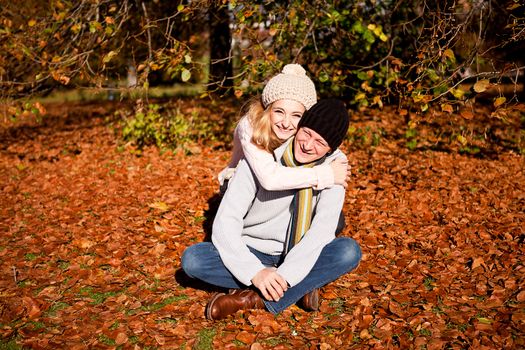 happy young couple smilin in colorful sunny autumn outdoor in park