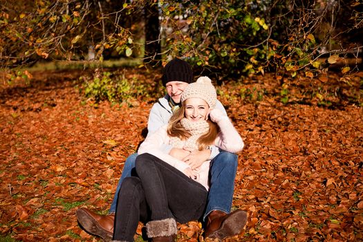 happy young couple smilin in colorful sunny autumn outdoor in park