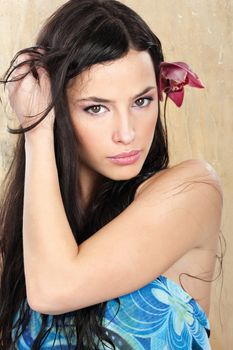 Pretty woman in blue dress in front of wet glass