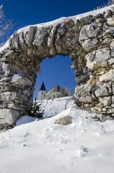 Through ruin view on St. Ursula church on top of the Plesivec mountain, highest elevation church in Slovenia at 1696m above sea level.