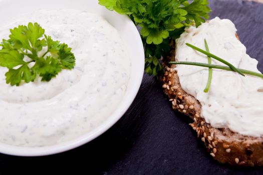 fresh tasty herbal creme cheese and bread on wooden table