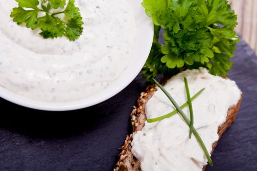 fresh tasty herbal creme cheese and bread on wooden table