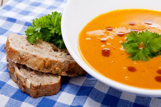 fresh tasty homemade pumpkin soup on wooden table with parsley and bread
