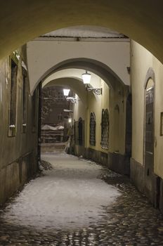 Scenic alley with arches covered with fresh snow, Ljubljana, Slovenia. 