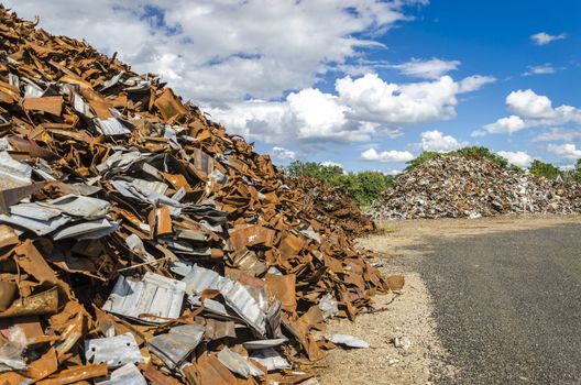 Scrapheap with piles of metal waste ready to be recycled.