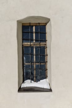 Old weathered window with grid and snow.