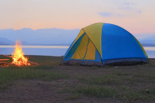 tent and campfire at sunset,beside the lake