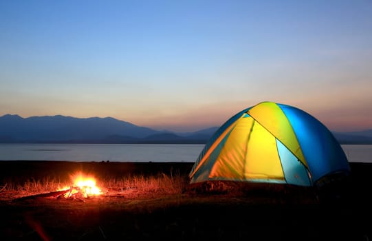 tent and campfire at sunset,beside the lake