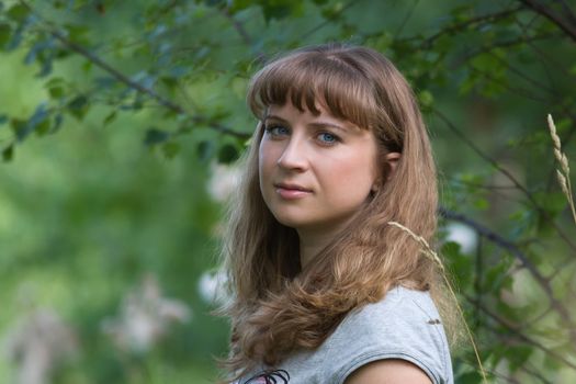 Portrait of a young girl in a summer forest